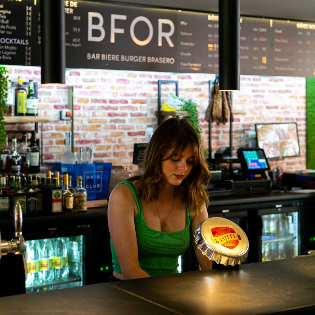 Une serveuse au comptoir de St-Maix, sous l'enseigne BFOR